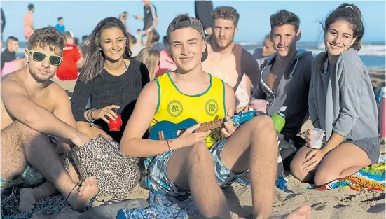  ?? ANDRES DELIA ?? Giuliano y sus amigos. Cada tarde, cuando cae el sol, se juntan a tomar mate y a tocar el ukelele en las playas de Pinamar.