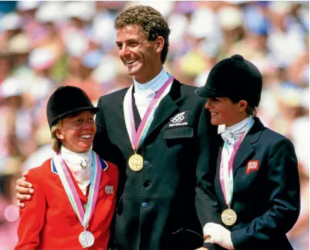  ?? PHOTO: PHOTOSPORT ?? Mark Todd flanked by Karen Stives, left, and Virginia Holgate-leng on the podium after winning with Charisma in Los Angeles in 1984.