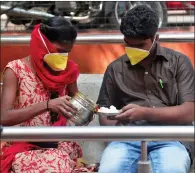  ??  ?? A couple wearing masks prepare to eat their lunch at government-run Gandhi Hospital in Hyderabad, India