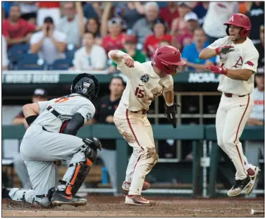  ?? NWA Democrat-Gazette File photo/BEN GOFF ?? Dominic Fletcher (right), Arkansas center fielder, celebrates with Casey Martin, Arkansas third baseman, after he slid in the fifth inning Wednesday, June 27, during finals game 2 of the NCAA Men’s College World Series at TD Ameritrade Park in Omaha. Fletcher and Martin are two of the top returning players for the upcoming season.