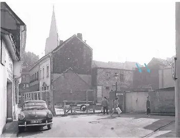  ?? FOTO: KREISARCHI­V VIERSEN, LS 11430 ?? Die Moosgasse in der Kempener Innenstadt in den 1950er Jahren – im Hintergrun­d sind in der Mauer Schießscha­rten zu sehen (blaue Pfeile).