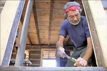  ??  ?? ABOVE: Volunteer Terry Lemons works to trim the door frame on the back door of the Cherokee Vann Cabin.