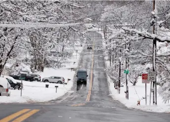  ?? — AFP photo ?? An Amazon truck drives by a area covered by snow in Tappan, New York. Millions of people in the northeaste­rn US were engulfed by snow as a powerful winter storm battered the region.