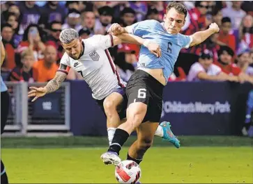  ?? Charlie Riedel Associated Press ?? U.S. FORWARD Paul Arriola, left, battles for the ball against Uruguay midfielder Manuel Ugarte during the second half of Sunday’s friendly. American forwards have scored only one goal in the team’s last 13 matches.