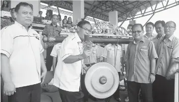  ??  ?? Jamit strikes the gong to officially declare open the 39th MSSB Kapit track and field sports competitio­n at Stadium Terbuka KPSU. Looking on from left are Robin Sabai (organising chairman of the event), SMK Selirik principal Jarit Jamit, Ringgit and...