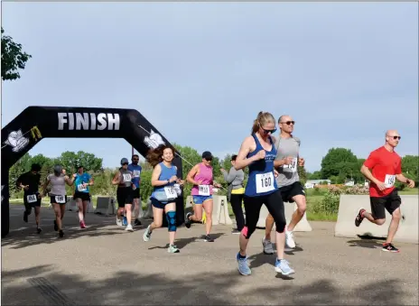  ?? Photos by Matthew Liebenberg/Prairie Post ?? Runners competing in the 10- and 16-kilometre distances sprint away from the starting line at the 2022 Southwest Run for Shelter, June 11.