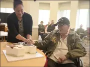  ?? ?? Warren MacQuarrie cuts the first piece of his special birthday cake with help from Patricia Hostetler, catering manager at Paradise Valley Estates, during his party Wednesday.