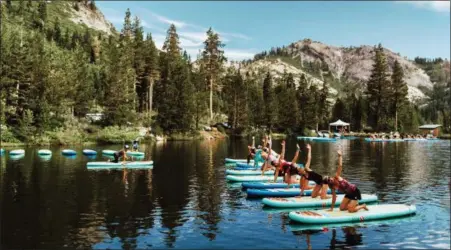  ?? AMANDA SENIOR — WANDERLUST VIA AP ?? This photo provided by Wanderlust, participan­ts work out on paddle boards during Wanderlust Squaw Valley 2017, in North Lake Tahoe. Wellness tourism is booming, with travelers not just staying fit while on the road, but planning entire trips with a...