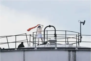  ?? ?? A protester makes it to the roof of a building at the Nustar Oil Depot in Clydebank