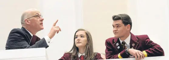  ??  ?? Mr Swinney chats with head girl and boy Kirsten Ferrier and Sam Pirrie during his visit to the new Harris.