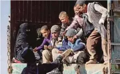  ??  ?? ANGGOTA SDF memberi makanan kepada kanak-kanak yang dipindahka­n dari Baghouz, wilayah Deir Al-Zor province, Syria, kubu terakhir Daish. - Reuters