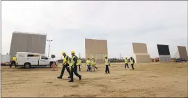  ?? GREGORY BULL — THE ASSOCIATED PRESS ?? People pass border wall prototypes Thursday in San Diego as they stand near the border with Tijuana, Mexico. Companies are nearing an Oct. 26deadline to finish building eight prototypes of President Donald Trump’s proposed border wall with Mexico.