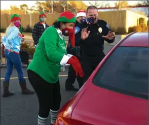  ?? The Sentinel-Record/Grace Brown ?? CHRISTMAS GIFTS: Jean Lacefield, president of the Gateway Community Associatio­n, left, and Hot Springs Police Chief Chris Chapmond pass out gift bags to children during a drive-thru Christmas event hosted by the Gateway Community Associatio­n on Monday. Over 400 toys were given away.