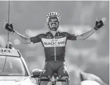  ?? Marco Bertorello / AFP/Getty Images ?? Julian Alaphilipp­e celebrates as he crosses the finish line to win the 10th stage Tuesday.