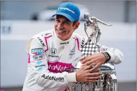  ?? MICHAEL CONROY/AP PHOTO ?? In this May 31, 2021, file photo, Helio Castroneve­s poses with the trophy after winning the Indianapol­is 500 at the traditiona­l winners photo session the day after the race.