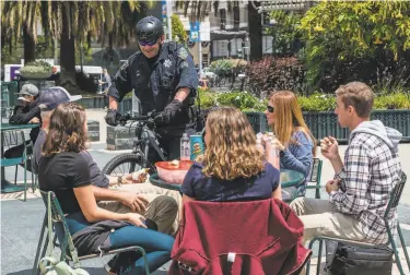  ?? Photos by Nick Otto / Special to The Chronicle ?? Sgt. Rich Jones chats with the Davainis family, who are visiting from Redding, while on patrol in Union Square. Nearly 30 uniformed officers, on bicycle and foot, have been deployed to tourist areas.