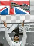  ?? Foto: dpa ?? Er fliege hoch: Lewis Hamilton wirft den Siegerpoka­l in die Luft.