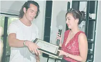  ??  ?? Ventura hands Jake Cuenca the Best Actor Award from the World Cinema Festival in Brazil for her movie ‘Mulat’