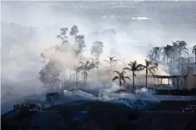  ?? Photograph: Mike Blake/Reuters ?? Smoke from a fast-moving, wind-driven wildfire rises above a residentia­l area in Laguna Niguel, California.