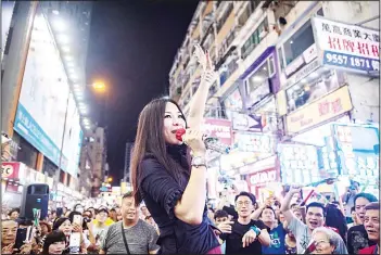  ??  ?? In this picture taken on July 29, a singer waves to supporters in a farewell performanc­e at the pedestrian zone of Sai Yeung
Choi Street South in Mong Kok, Hong Kong. (AFP)