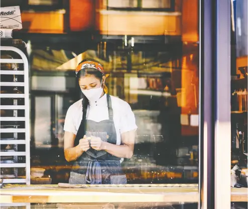  ?? NINA WESTERVELT / BLOOMBERG ?? A worker wears a mask at a restaurant in Memphis on Sunday. In the U. S. and the U.K., in particular, many young respondent­s told the Financial Times they felt the government had been inconsiste­nt on COVID and slow to act.