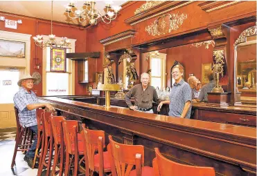  ?? PHOTOS BY MELANIE METZ/FOR THE SANTA FE NEW MEXICAN ?? ABOVE: From left, Bob Sarr, former president of Santa Fe Southern Railway; Karl Ziebarth, CEO of Santa Fe Southern Railway; and new owner Allan Affeldt discuss plans Friday for the historic Legal Tender restaurant/saloon in Lamy. BELOW: The Legal Tender, then known as the Pink Garter, was a nightspot popular with servicemen in transit along the Atchison, Topeka and Sante Fe Railway during World War II. It currently houses a museum.