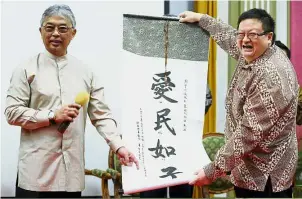  ?? — Bernama ?? Auspicious strokes: Tengku Abdullah receiving a memento from Ong during an audience with Chinese youth organisati­ons.