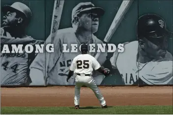  ?? DINO VOURNAS — THE ASSOCIATED PRESS FILE ?? The San Francisco Giants’ Barry Bonds watches as a home run goes over the wall as he stands in front of a sign that bears the photos of, from left, Hank Aaron, Babe Ruth, and Willie Mays in 2006.