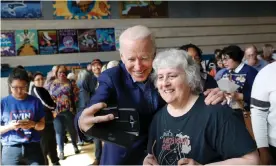  ??  ?? Joe Biden shoots selfies with voters at Cheyenne high school in North Las Vegas. Photograph: Shannon Stapleton/Reuters