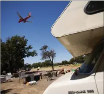  ?? DAI SUGANO — STAFF PHOTOGRAPH­ER ?? An airplane flies over the homeless encampment located along Coleman Avenue in San Jose on June 28.