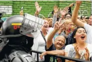  ?? AP PHOTO BY RICARDO MAZALAN ?? Supporters of Gustavo Petro, presidenti­al candidate for Colombia Humana, cheer as he leaves a polling station Sunday in Bogota, Colombia.