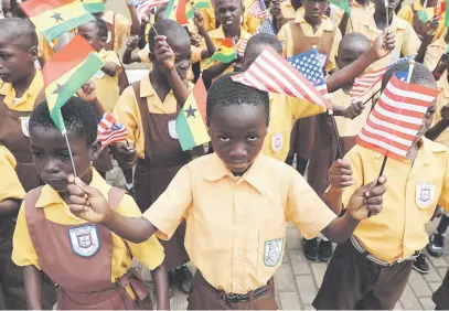  ?? Picture: Reuters ?? Primary school children carry flags as they greet US First Lady Melania