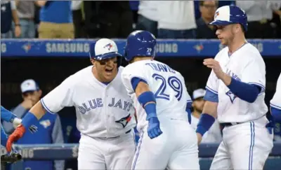  ?? JON BLACKER, THE CANADIAN PRESS ?? Blue Jays Troy Tulowitzki and Justin Smoak celebrate Devon Travis’ grand slam against the Texas Rangers in the second inning in Toronto on Friday.