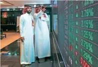  ?? — Bloomberg ?? Visitors watch stock movements on screens inside the Saudi Stock Exchange in Riyadh.