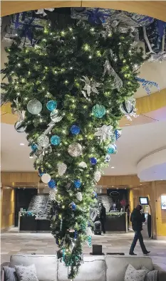  ?? THE CANADIAN PRESS ?? No, no ... you haven’t had too much eggnog. The centrepiec­e at the Fairmont Vancouver Airport hotel in Richmond, B.C., is really an upside down Christmas tree.