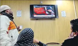  ?? AP FILE ?? People watch a news report on TV about Mullah Fazlullah at a coffee shop in Islamabad.