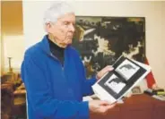  ?? Damian Dovarganes, The Associated Press ?? In this May 31 photo, Sen. Robert Kennedy aide Paul Schrade holds an evidence photo of gunman Sirhan Sirhan’s revolver with the eight expended shell casings found in the chamber, and the Weisel, Goldstein, and Kennedy bullets, at his home in Los Angeles.