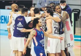  ?? FOTO: EFE ?? Shane Larkin se retira mientras los jugadores del Madrid se abrazan al final del choque