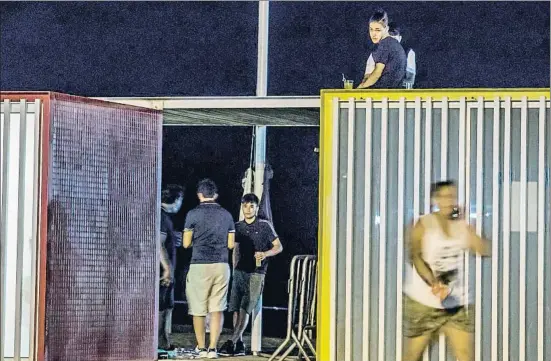  ?? LLIBERT TEIXIDÓ ?? La alternativ­a al podio. Unos jóvenes beben de madrugada subidos al techo de unos lavabos en la playa de Castelldef­els