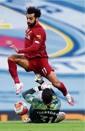  ?? — aP ?? Flying high: liverpool’s Mohamed Salah leaps over Manchester City goalkeeper Ederson during the English Premier league match at the Etihad.