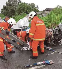  ??  ?? ANGGOTA bomba bertungkus lumus mengeluark­an mangsa yang maut.