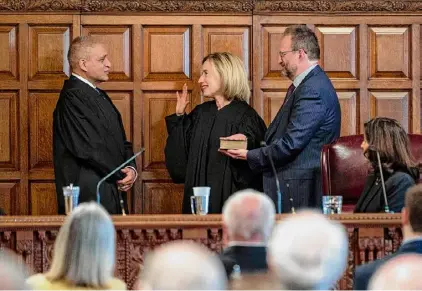  ?? Lori Van Buren/ Times Union archive ?? Chief Judge Rowan Wilson swears in Court of Appeals Judge Caitlin Halligan while her husband, Marc Falcone, holds the Bible during an investitur­e ceremony in the court’s chambers in Albany in June.