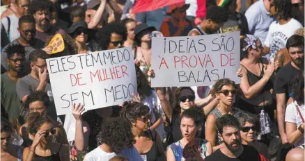  ?? MAURO PIMENTEL AGENCE FRANCE-PRESSE ?? Dans les rues de Maré, la favela d’où était originaire Marielle Franco, des partisans de l’élue municipale se sont rassemblés pour lui rendre hommage. Des pancartes comportaie­nt les messages «Une femme sans peur leur fait peur» et «Les idées sont à...