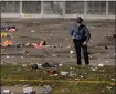  ?? ASSOCIATED PRESS FILE PHOTO ?? A law enforcemen­t officer stands amid debris as he looks around the scene following a shooting at the Kansas City Chiefs Super Bowl celebratio­n in Kansas City, Mo. on Wednesday.