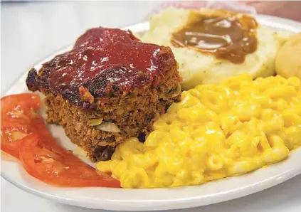  ?? MARK GILLILAND PHOTOS ?? A slice of meatloaf served with mashed potatoes and mac and cheese is a hot plate of comfort food at Track’s End.