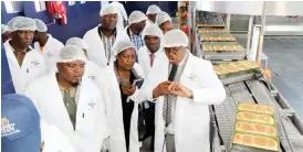  ??  ?? Baker’s Inn chief executive officer Mr Ngoni Mazango (extreme right) leads a tour of Leonard Plant 3 after official opening in Bulawayo on Friday