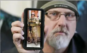  ?? RICK BOWMER/ASSOCIATED PRESS ?? Matthew Butler, who spent 27years in the Army, holds a 2014photog­raph of himself during his last deployment in Kabul Afghanista­n, on Wednesday, March 30, 2022, in Sandy, Utah. Butler is now one of the military veterans in several U.S. states who are helping convince conservati­ve lawmakers to take cautious steps toward allowing the therapeuti­c use of hallucinog­enic mushrooms and other psychedeli­c drugs. The therapeuti­c used of so-called magic mushrooms and other psychedeli­c drugs is making inroads in several U.S. states, including some with conservati­ve leaders, as new research points to their therapeuti­c value and military veterans who have used them to treat posttrauma­tic stress disorder become advocates.