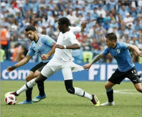  ?? THE ASSOCIATED PRESS ?? France’s Paul Pogba, center, clashes with Uruguay’s Luis Suarez, left, and Lucas Torreira during a quarterfin­al World Cup match on Friday.