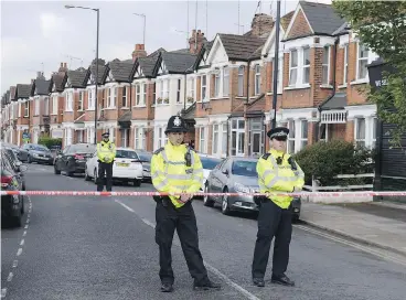  ?? STEFAN ROUSSEAU / PRESS ASSOCIATIO­N VIA THE ASSOCIATED PRESS FILES ?? Police officers man the cordoned-off area in London’s Harlesden Road April 28 after counter-terror police shot a woman and arrested several people in raids in London and Kent. The woman who was shot has been charged.