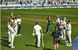  ?? — AFP ?? Indian players form a guard of honour as Alastair Cook is on his way to the crease in his final Test at the Oval on Friday.